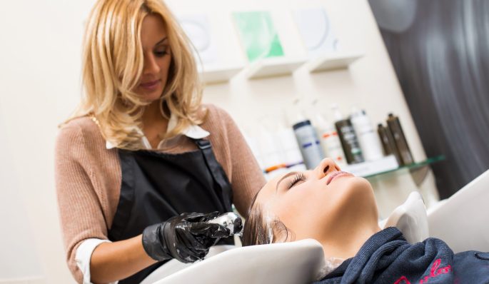 Hairdresser salon. Woman during hair wash